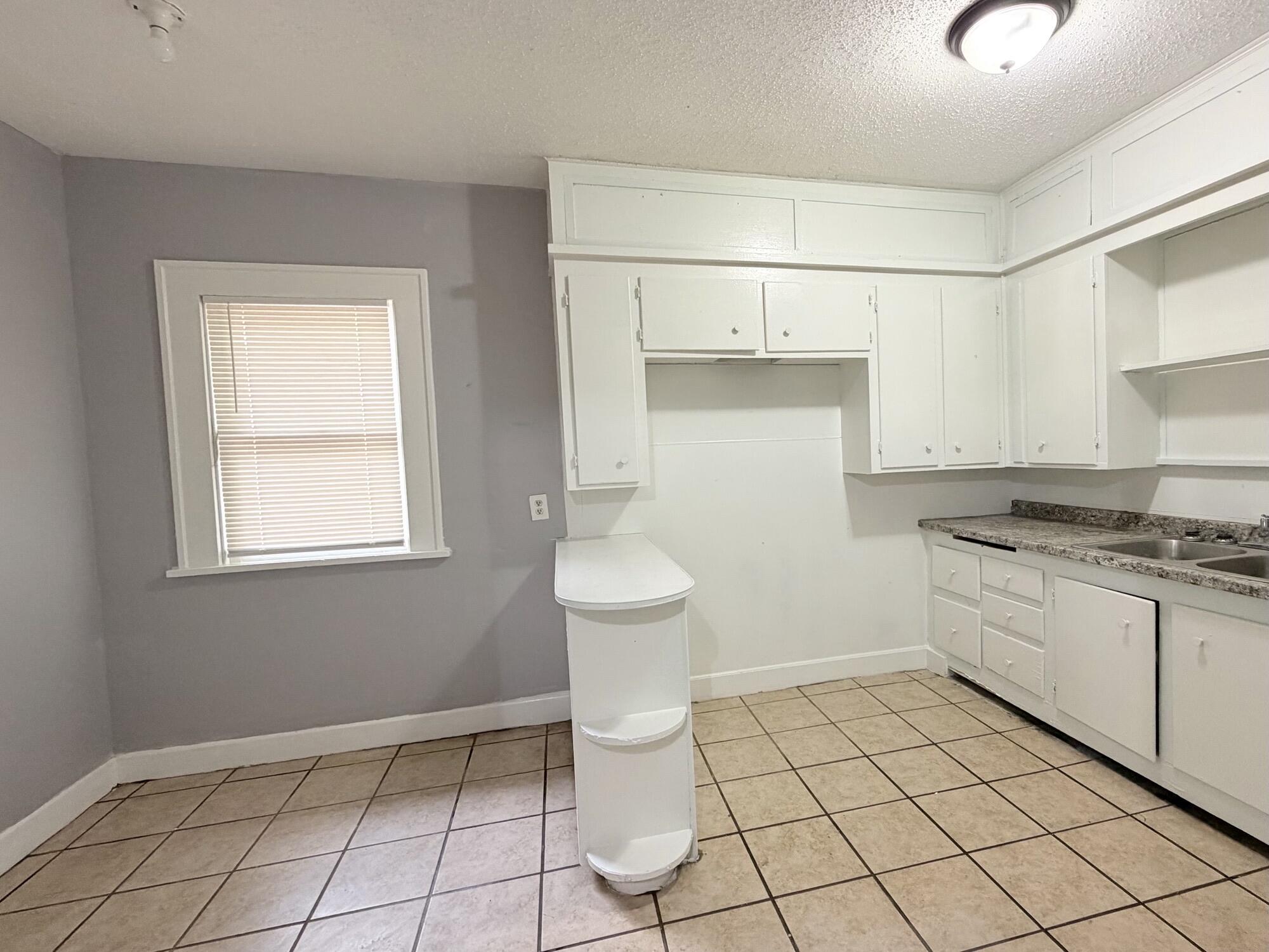 2119 15th Street Lubbock, TX 79401 - Photo 7 of 15 a bathroom with a sink a toilet and a mirror