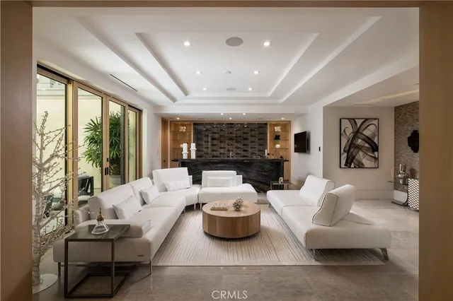 a living room with furniture and floor to ceiling windows