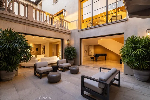 a living room with stainless steel appliances granite countertop lots of furniture and a large window