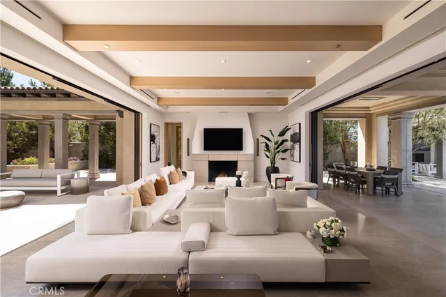 a living room with furniture a large window and a chandelier