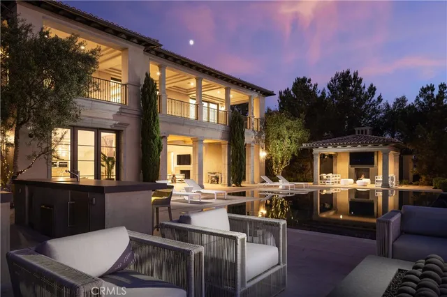 a view of a patio with couches table and chairs with wooden floor and fence