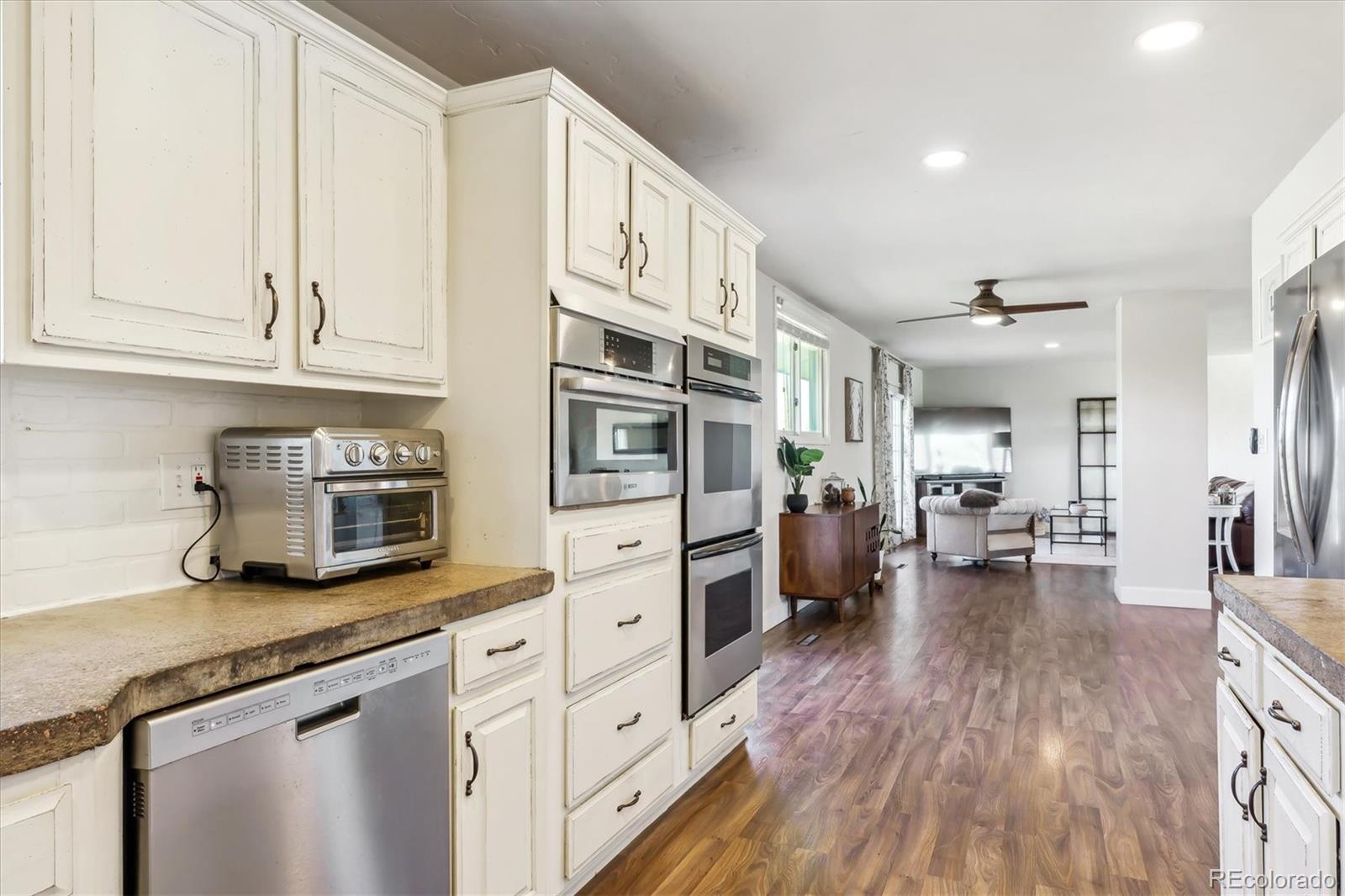 36901 View Ridge Drive Elizabeth, CO 80107 - Photo 10 of 31 a kitchen with stainless steel appliances granite countertop a refrigerator oven stove cabinets and wooden floor