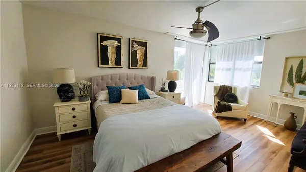 a bedroom with a bed and a flat tv screen on the dresser