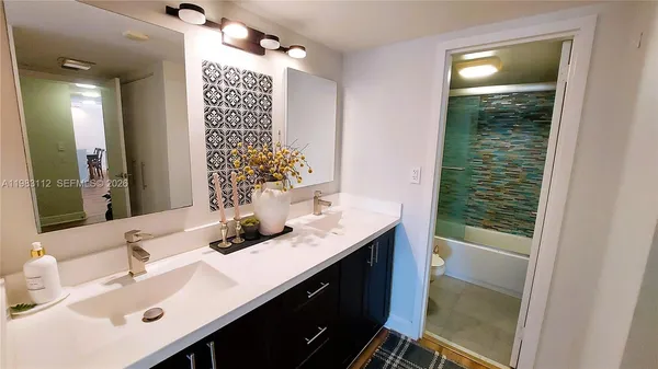 a bathroom with a sink vanity granite and a mirror