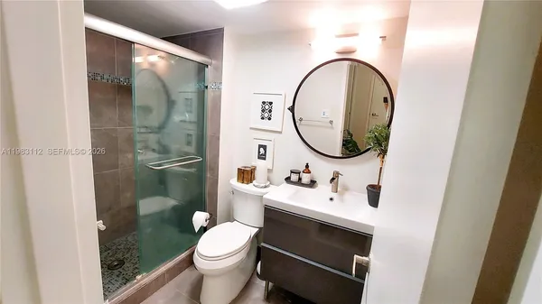 a bathroom with a sink vanity mirror and toilet