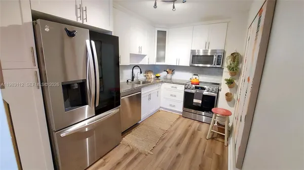 a kitchen with stainless steel appliances a refrigerator sink and microwave