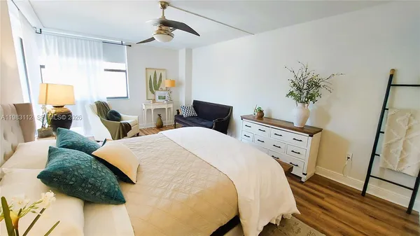 a bed room with two bed and a potted plant