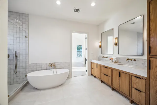 a bathroom with a double vanity sink mirror double and bathtub