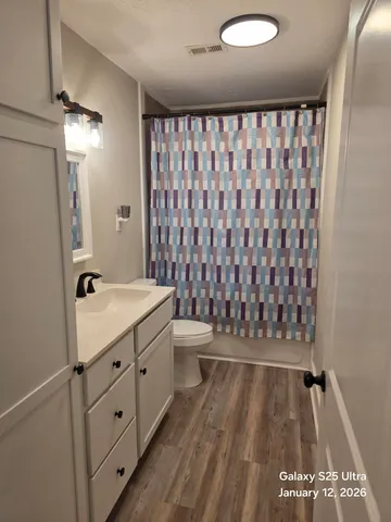 a bathroom with a granite countertop sink toilet and shower