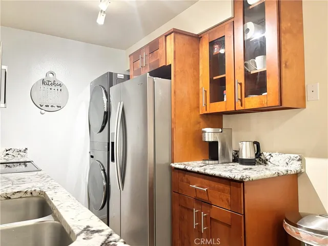 a kitchen with stainless steel appliances granite countertop a refrigerator and a sink