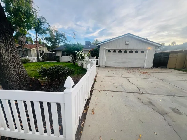 a view of a house with a yard and potted plants
