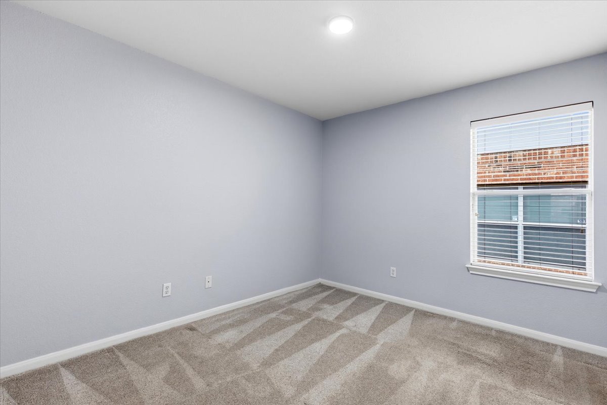 17812 Masi Loop Pflugerville, TX 78660 - Photo 30 of 38 Neutral gray wall paint, patterned carpeting, white baseboards, and a single recessed ceiling light fixture