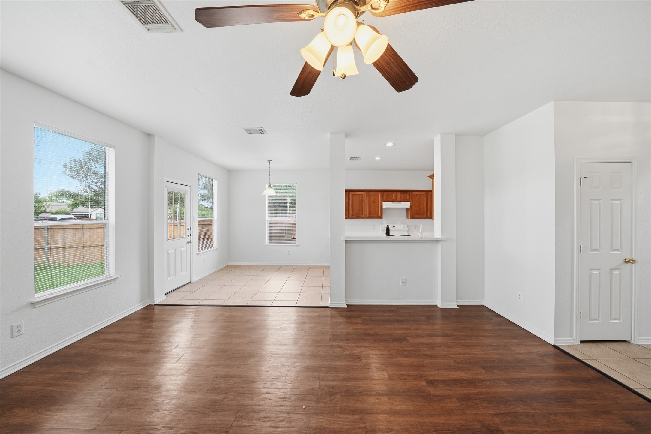 118 Invierno Street Kyle, TX 78640 - Photo 6 of 37 A welcoming interior with wood flooring extending into a tiled kitchen space, perfect for everyday living.
