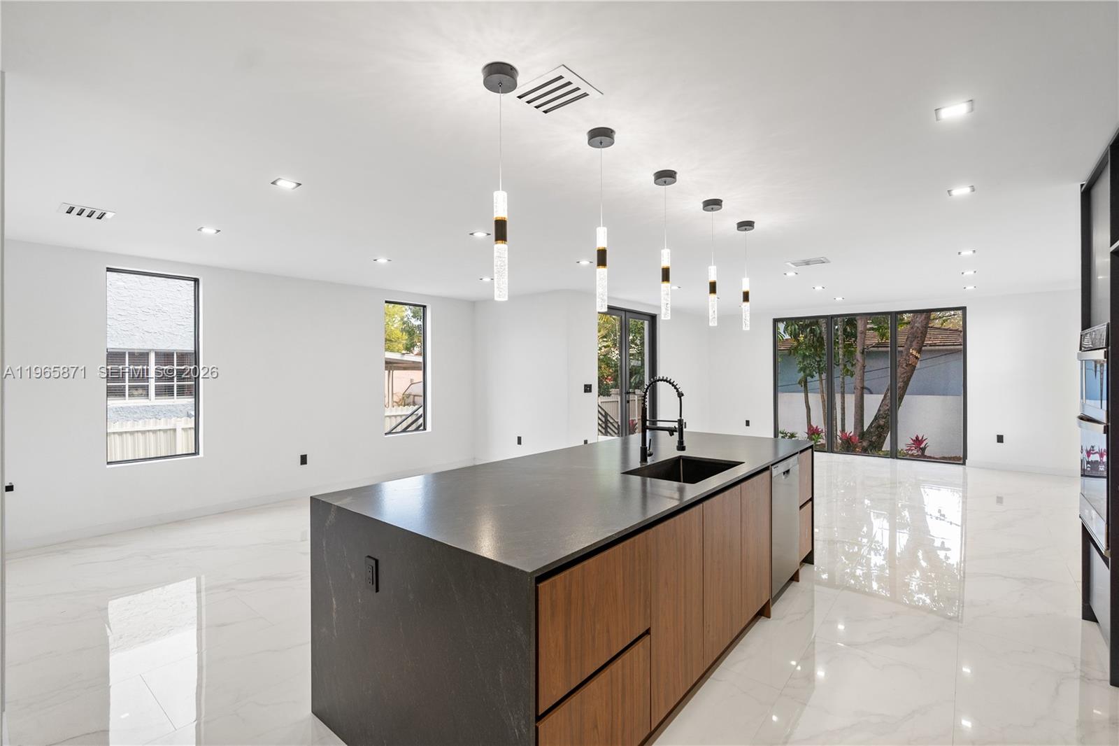 1644 Northwest 8th Terrace Miami, FL 33125 - Photo 12 of 60 a kitchen with stainless steel appliances kitchen island a large counter top and a refrigerator