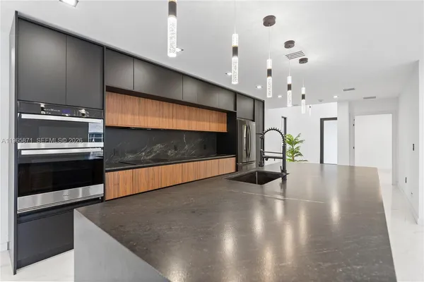 a large kitchen with stainless steel appliances kitchen island a large counter top and oven