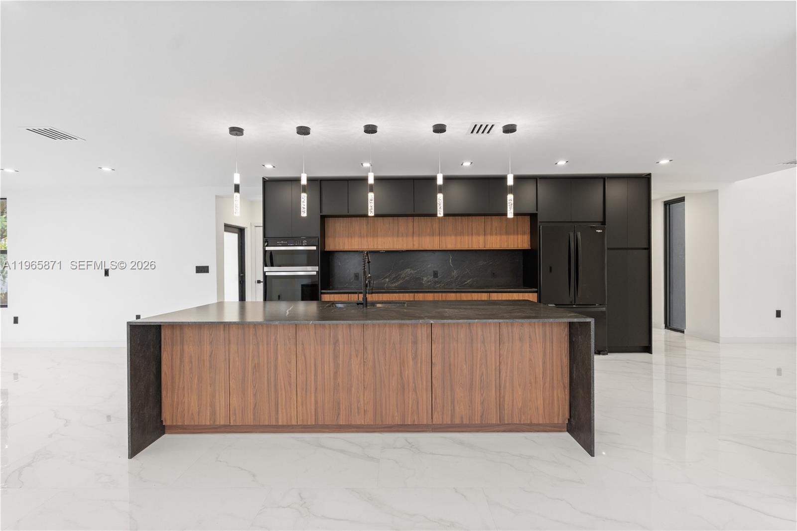 1644 Northwest 8th Terrace Miami, FL 33125 - Photo 15 of 60 a large kitchen with stainless steel appliances kitchen island a large counter top and oven