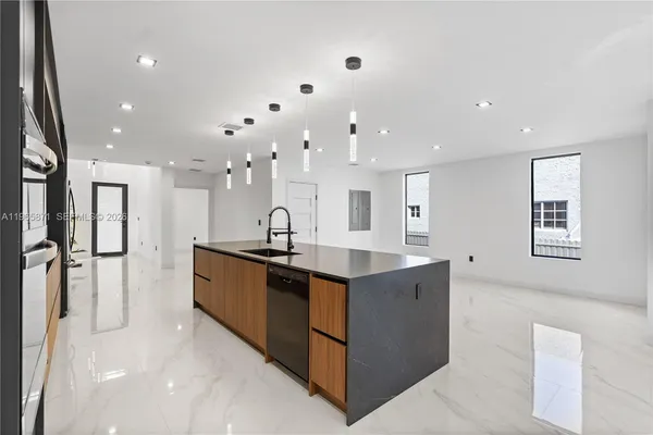a kitchen with stainless steel appliances kitchen island granite countertop a stove and a microwave oven