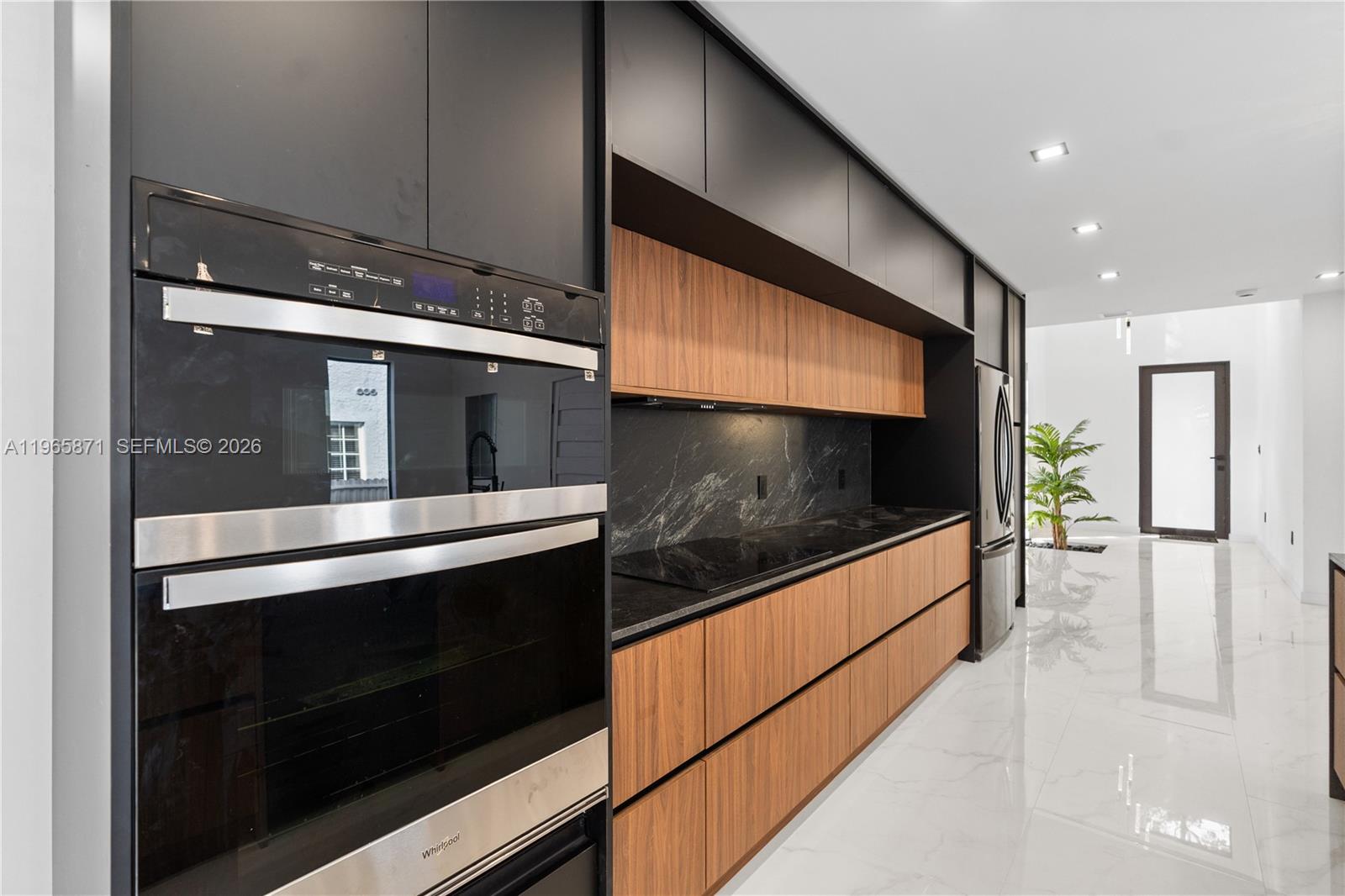 1644 Northwest 8th Terrace Miami, FL 33125 - Photo 17 of 60 a kitchen with stainless steel appliances kitchen island granite countertop a stove and a microwave oven