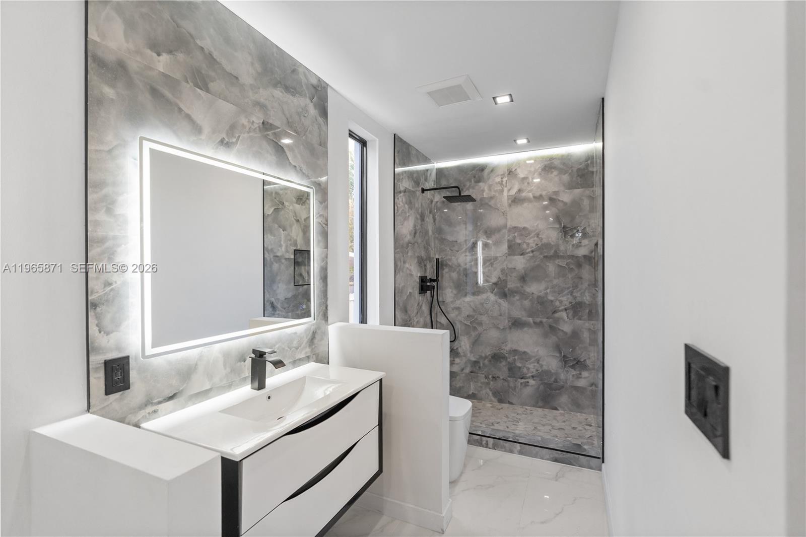 1644 Northwest 8th Terrace Miami, FL 33125 - Photo 25 of 60 a bathroom with a sink a toilet a mirror and shower