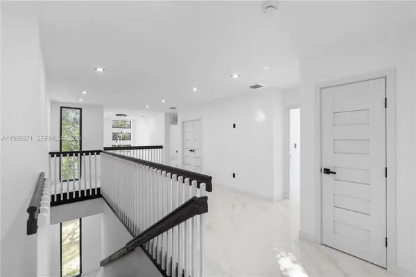 a picture of a bedroom with wooden floor and a chandelier