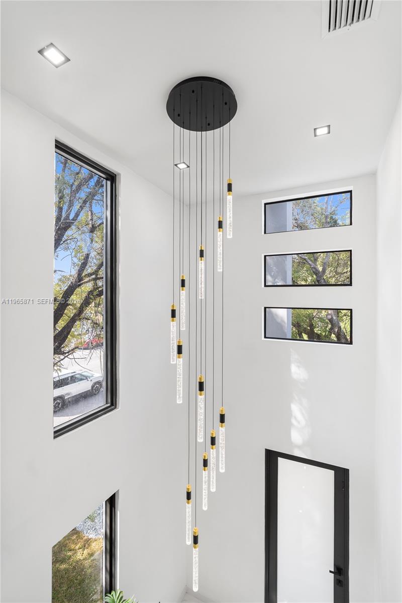 1644 Northwest 8th Terrace Miami, FL 33125 - Photo 32 of 60 a picture of a bedroom with wooden floor and a chandelier