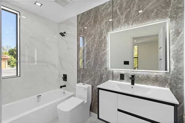 a white toilet sitting next to a bath tub