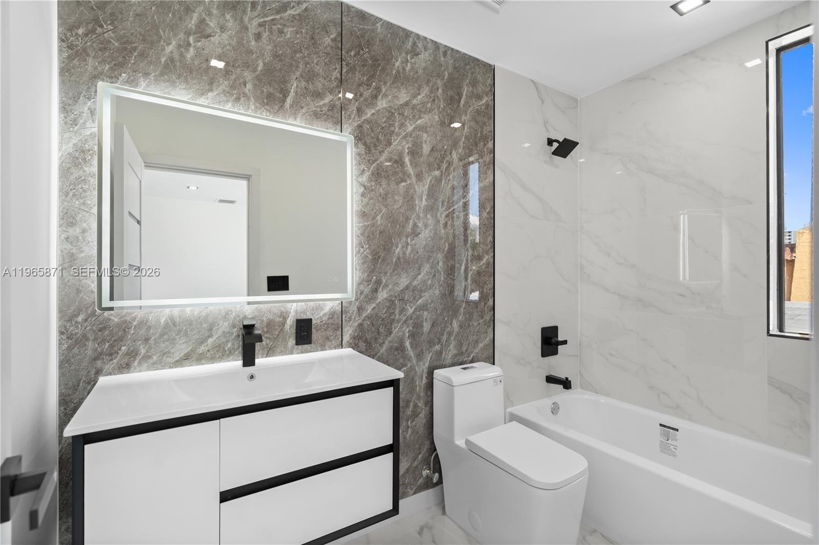 1644 Northwest 8th Terrace Miami, FL 33125 - Photo 40 of 60 a bathroom with a sink toilet a mirror and shower