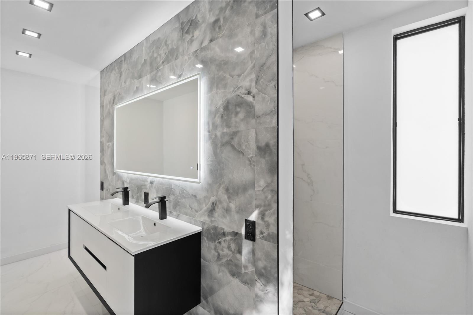 1644 Northwest 8th Terrace Miami, FL 33125 - Photo 50 of 60 a bathroom with a sink vanity and a mirror