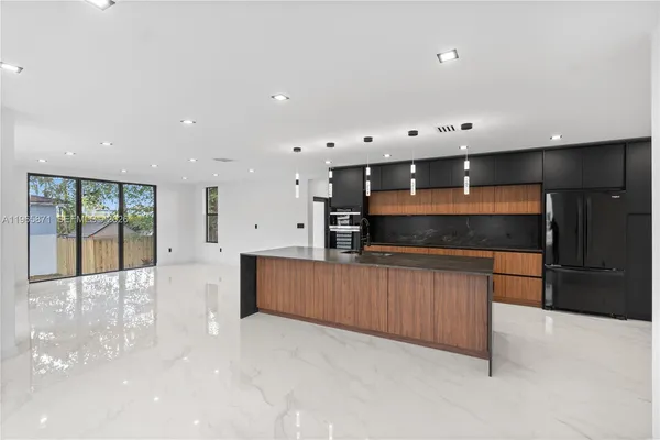 a large kitchen with stainless steel appliances a large counter top