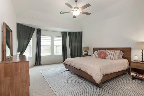 a bedroom with a large bed and a chandelier