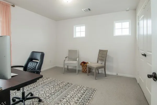 a bedroom with a bed chair and a lamp on desk