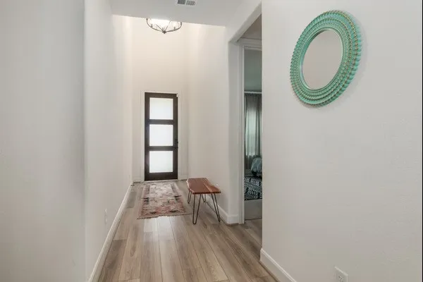 a living room with stainless steel appliances granite countertop furniture wooden floor and a view of kitchen