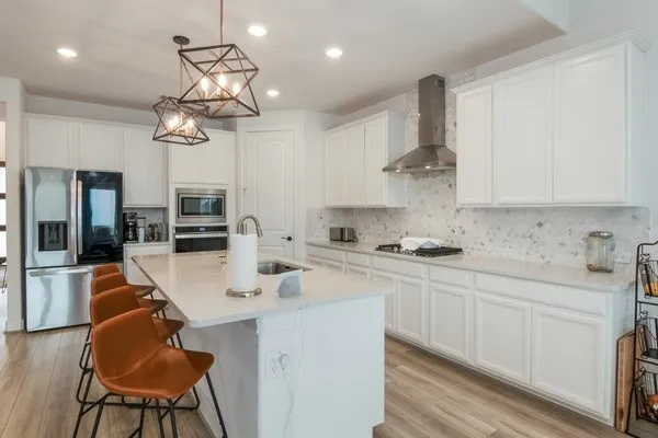 a kitchen with a dining table chairs sink and cabinets
