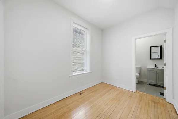 a view of a room with wooden floor and a window