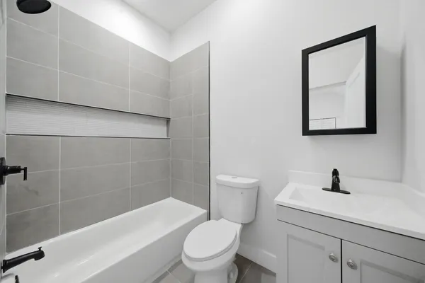 a bathroom with a toilet a sink a mirror and bathtub