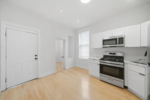 a kitchen with a stove a microwave and window