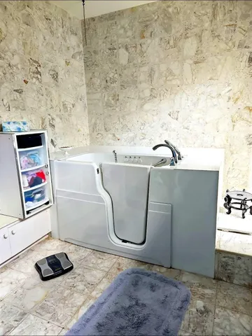 a spacious bathroom with a granite countertop sink and a mirror