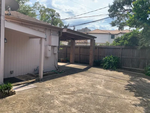 a view of a brick house with a yard and plants