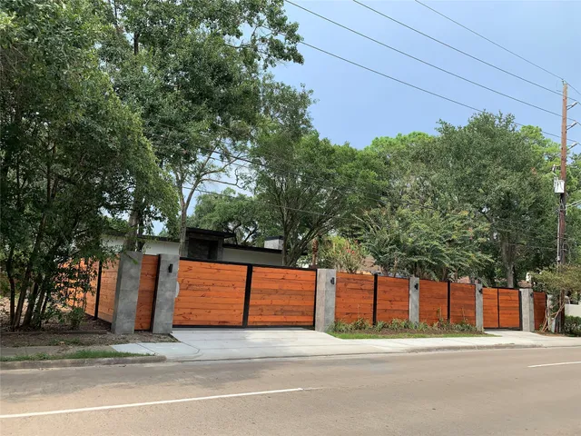a front view of a house with a yard and potted plants