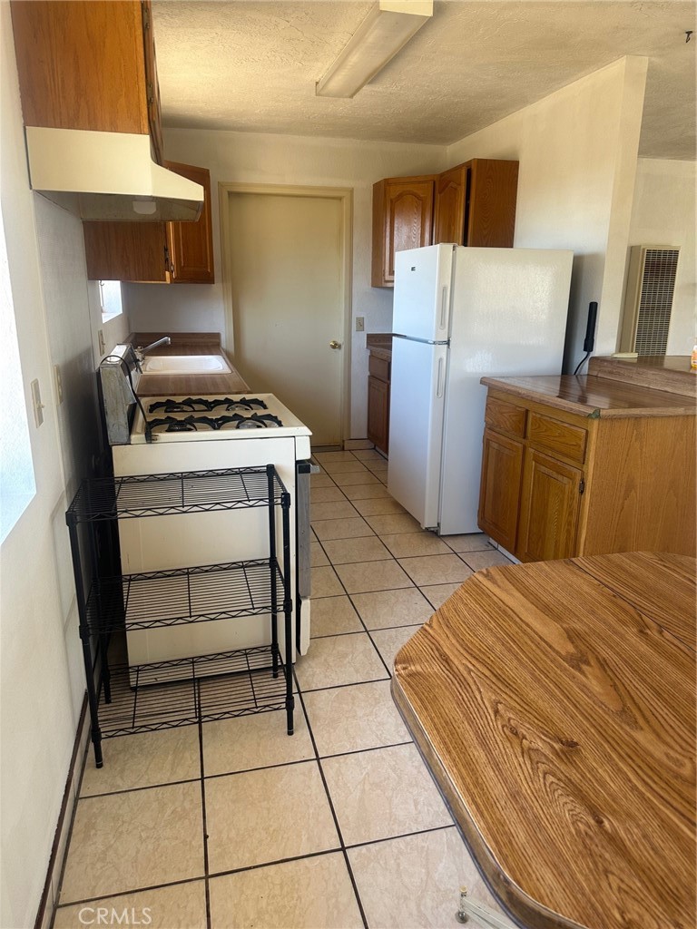 9772 Alamo Road Lucerne Valley, CA 92356 - Photo 11 of 24 a kitchen with a stove a refrigerator and cabinets