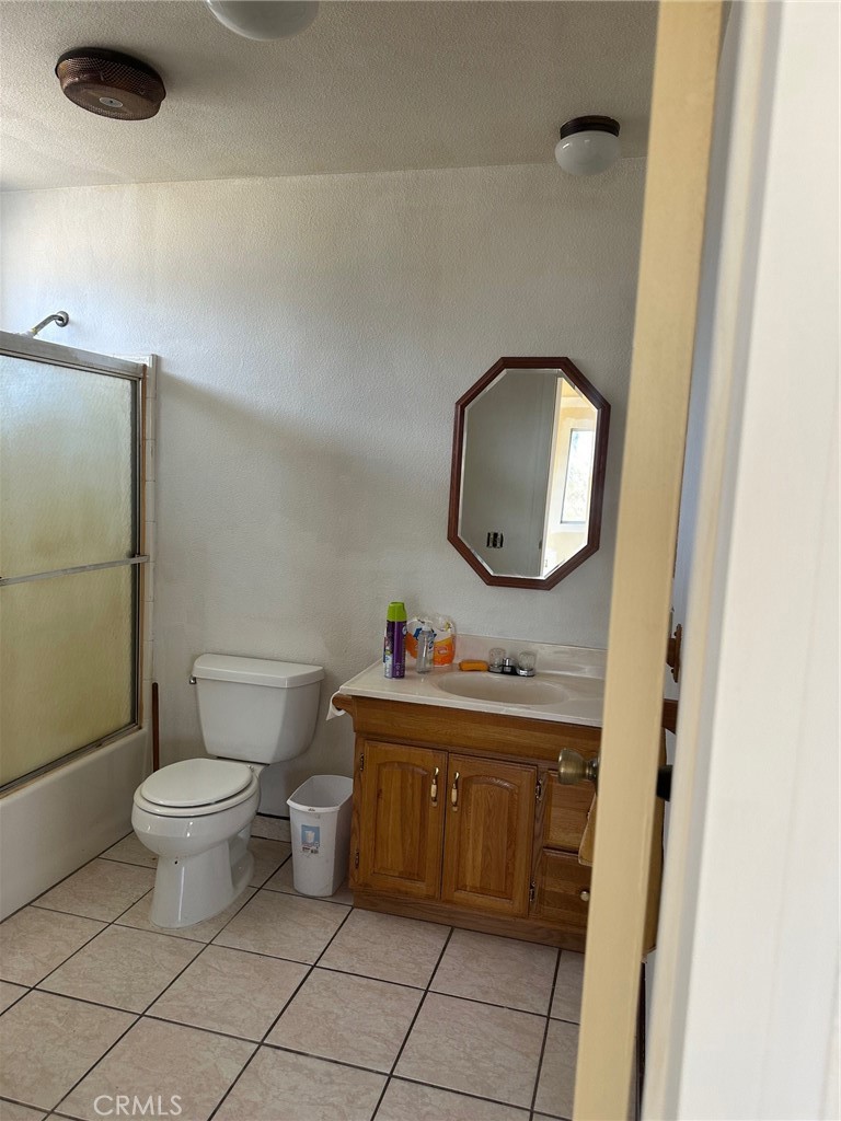 9772 Alamo Road Lucerne Valley, CA 92356 - Photo 12 of 24 a bathroom with a toilet a sink and a mirror