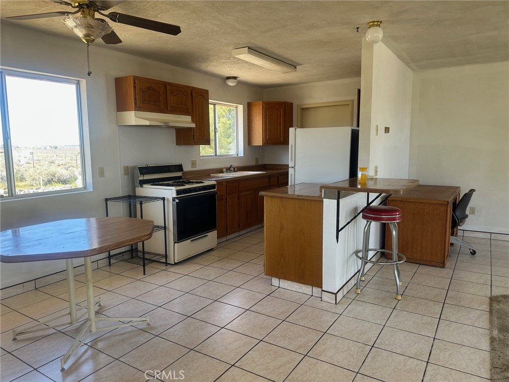 9772 Alamo Road Lucerne Valley, CA 92356 - Photo 10 of 24 a kitchen with granite countertop a stove a sink and a microwave