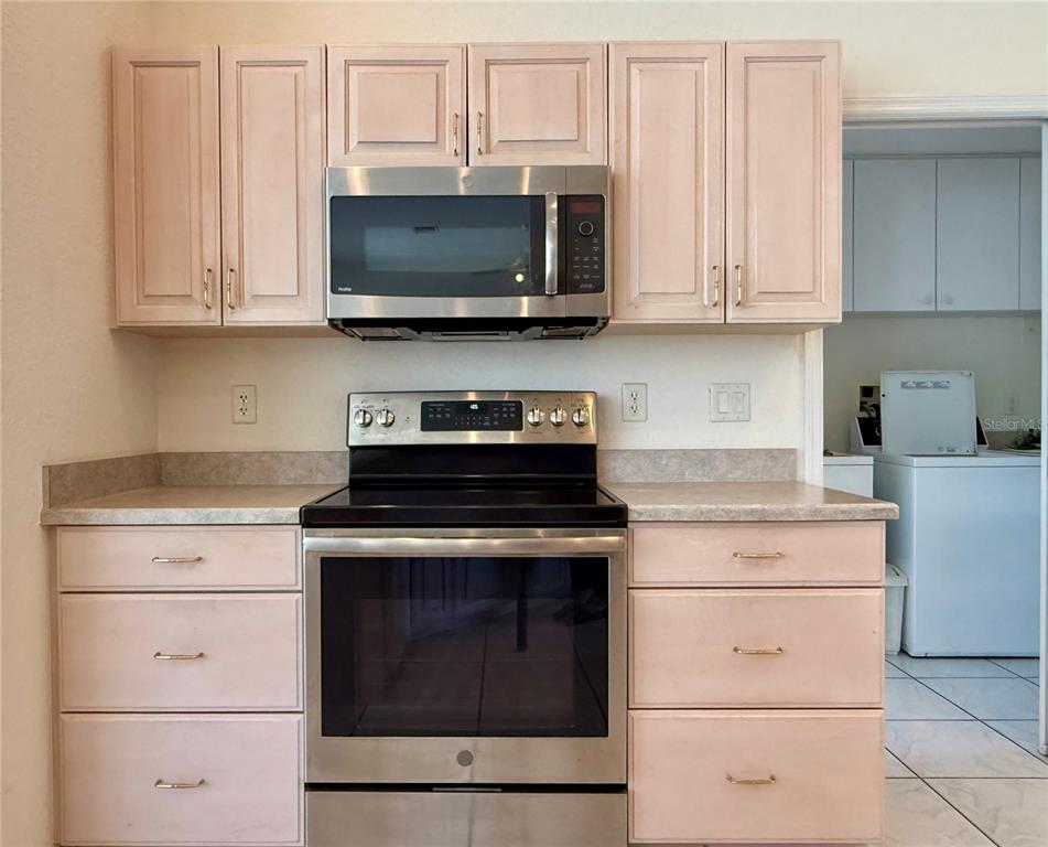 5614 Angelo Circle Sebring, FL 33872 - Photo 12 of 39 a kitchen with white cabinets and stainless steel appliances