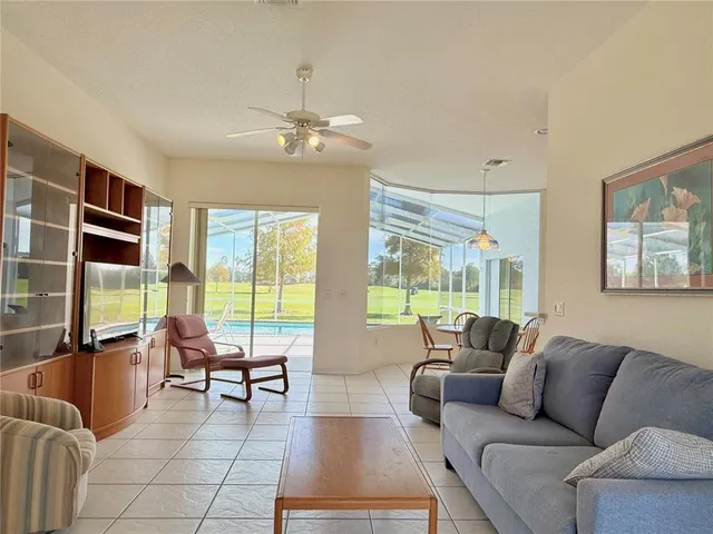 a living room with furniture and floor to ceiling windows