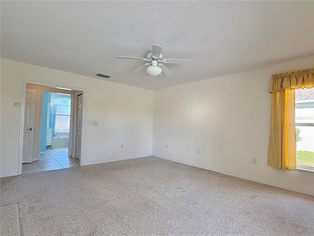 5614 Angelo Circle Sebring, FL 33872 - Photo 20 of 39 an empty room with windows and fan