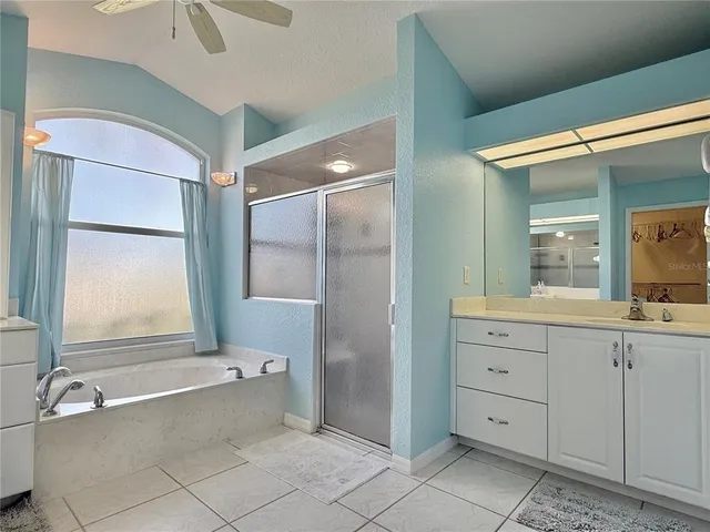 a bathroom with a bathtub a sink and a large mirror