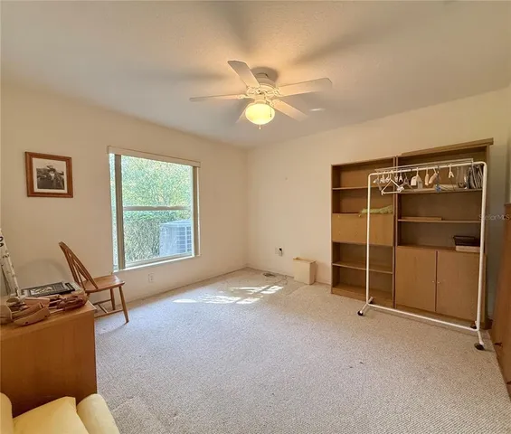 a view of a livingroom with furniture and a ceiling fan
