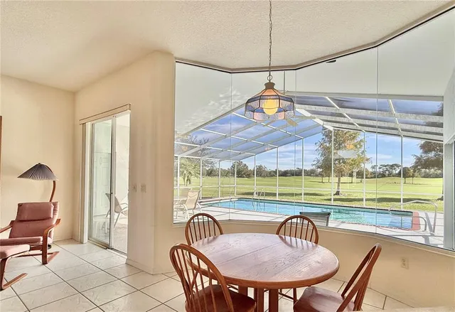 a view of a dining room and a table chairs swimming pool and wooden floor