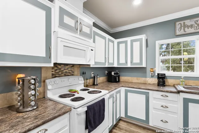 a kitchen with stainless steel appliances granite countertop a sink stove and cabinets