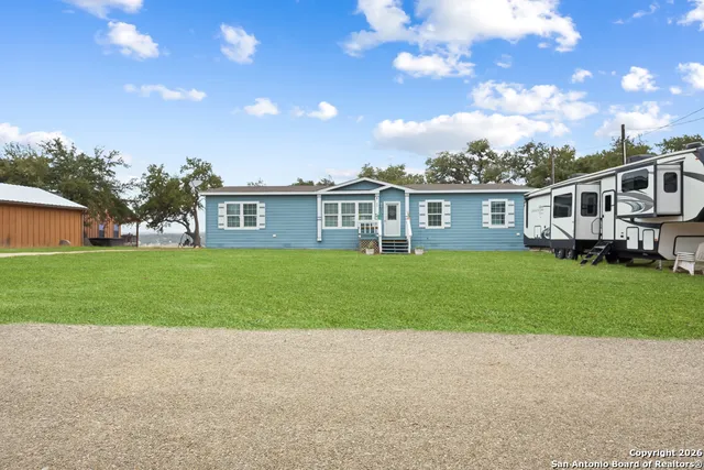 a front view of house with yard and green space
